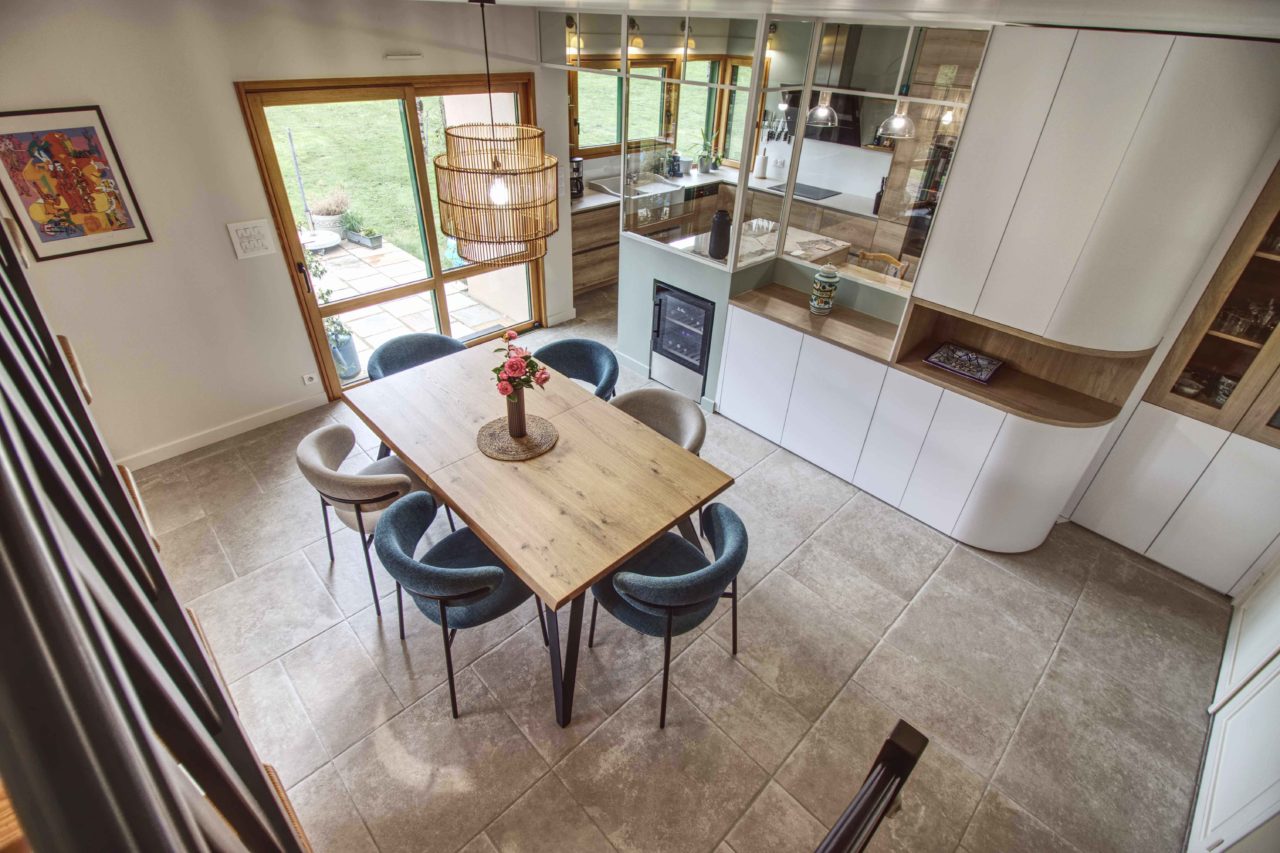 Salle à manger moderner avec meuble sur mesure en arrondi. Verrière vers cuisine.
